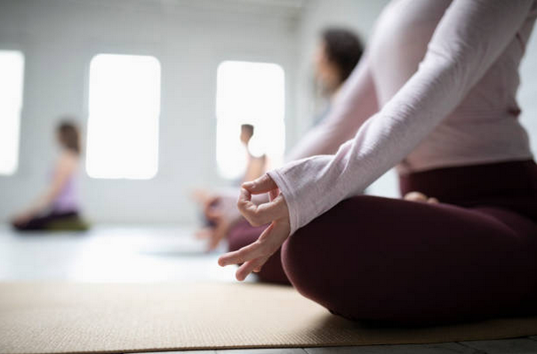 Gros plan sur une femme en position tailleur lors d'une séance de yoga