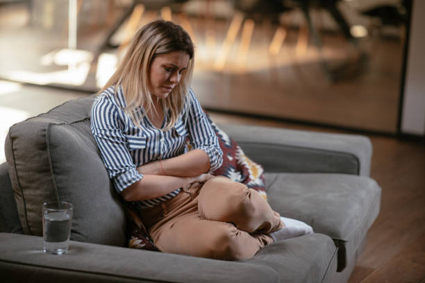 Femme qui se tient le ventre en signe de douleur