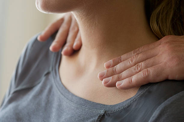 Jeune femme en train de se faire masser les épaules et la nuque pour réduire ses douleurs