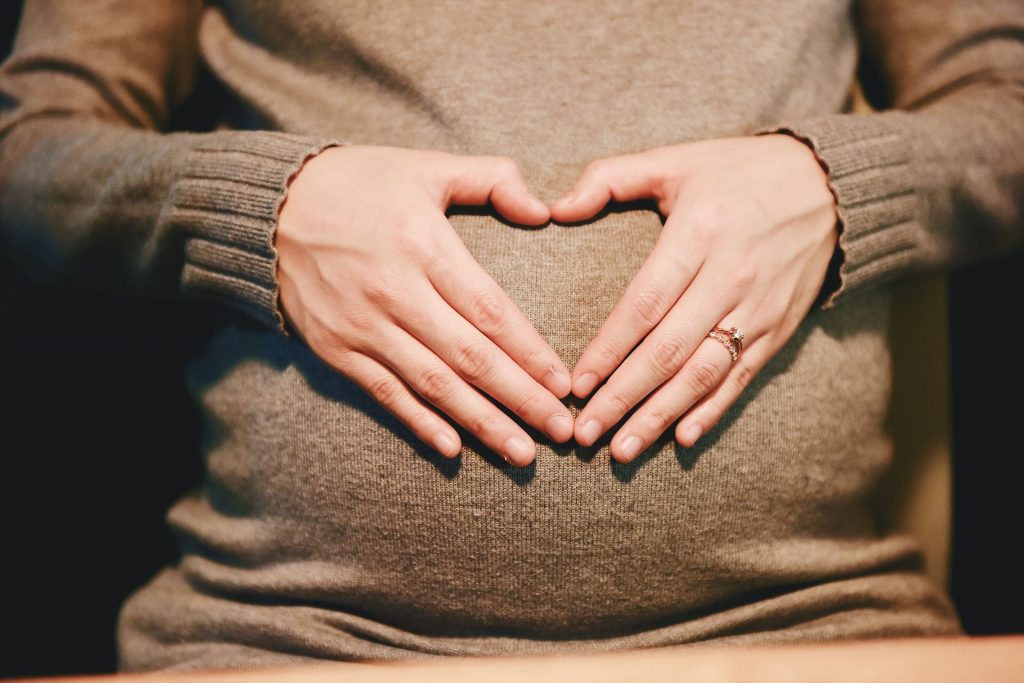 Femme enceinte qui a les mains posées sur son ventre