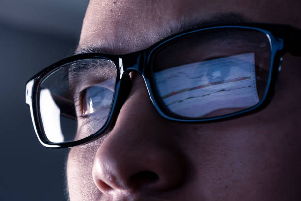 Jeune homme qui porte des lunettes pour travailler sur son ordinateur