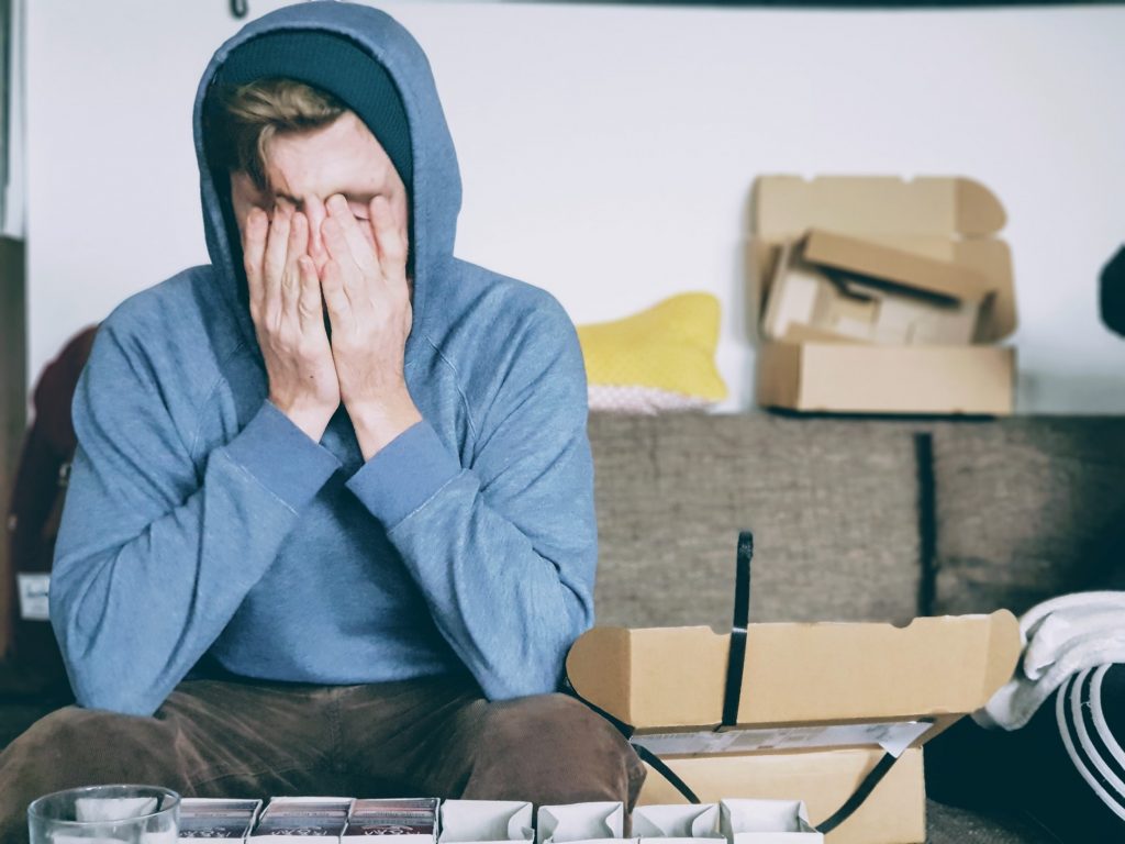 Jeune homme stressé par son déménagement qui prépare ses cartons
