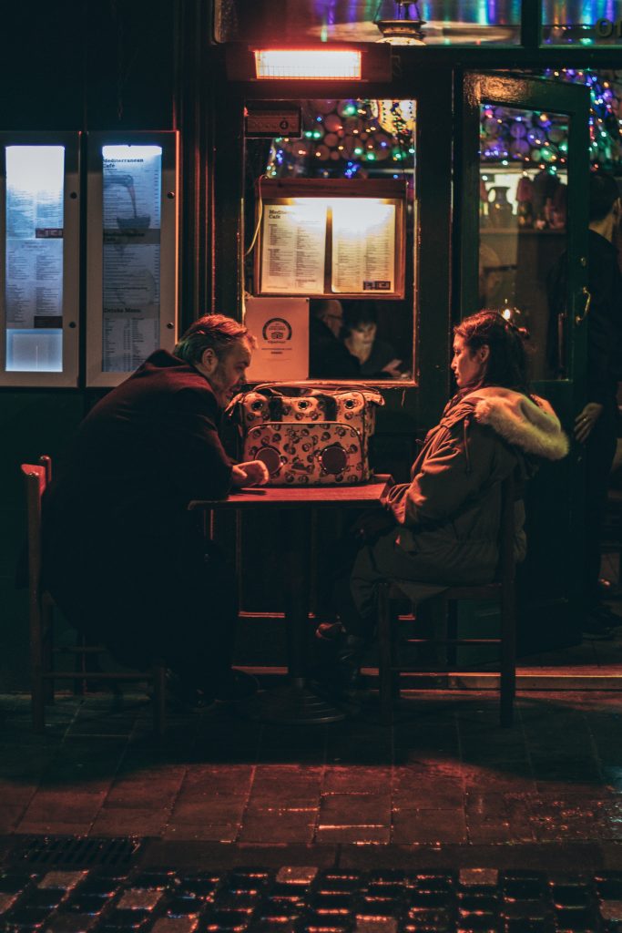 Un homme et une femme qui se font face à la table d'une terrasse